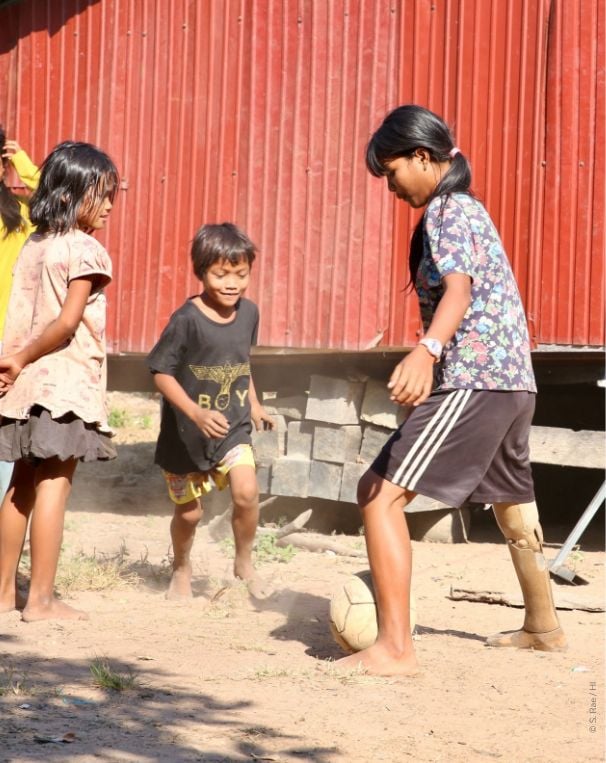 deux enfants jouant au foot dont un avec une prothèse