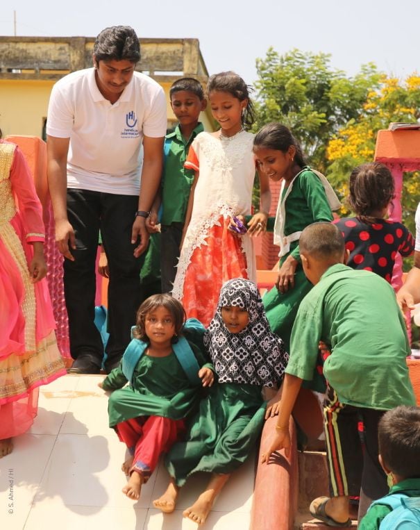 Des enfants et une personne avec un tshirt HI