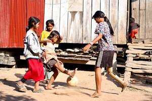 Srey Neang joue au foot dans la cour avec ses amis.