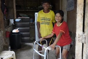 Aux Philippines, une femme se tient debout grâce à un déambulateur.
