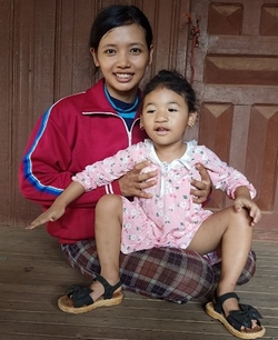 Au Cambodge, une mère tient sa fille de 9 ans dans ses bras.