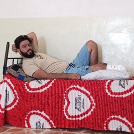 Un jeune homme amputé d'une jambe est allongé sur un lit.
