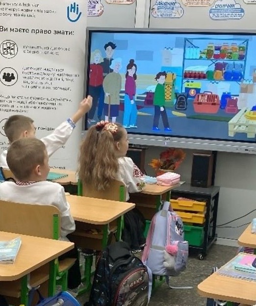 Dans une classe en Ukraine, sensibilisation des enfants aux risques liés aux engins explosifs.