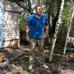 Un homme debout dans son jardin.