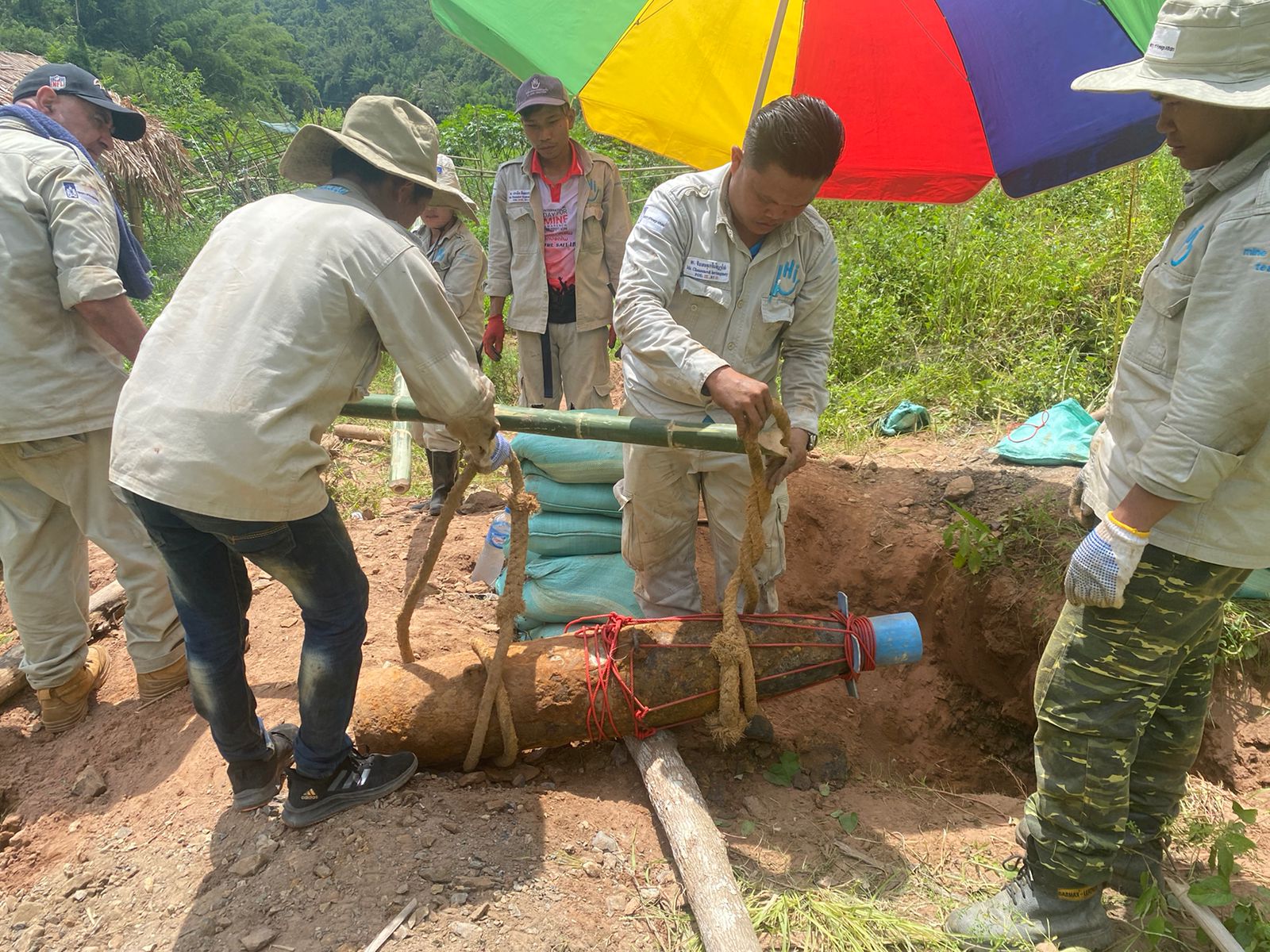 Des personnes déplacent délicatement une bombe trouvée au Laos.