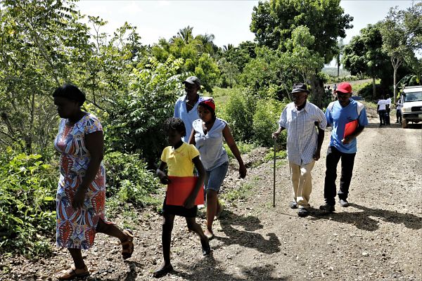 Un bénévole aide une personne âgée lors d’un exercice de simulation de catastrophe naturelle à Haïti / Handicap International