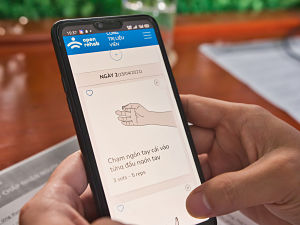 Un utilisateur navigue dans l'application mobile OpenTeleRehab de HI sur un smartphone. 