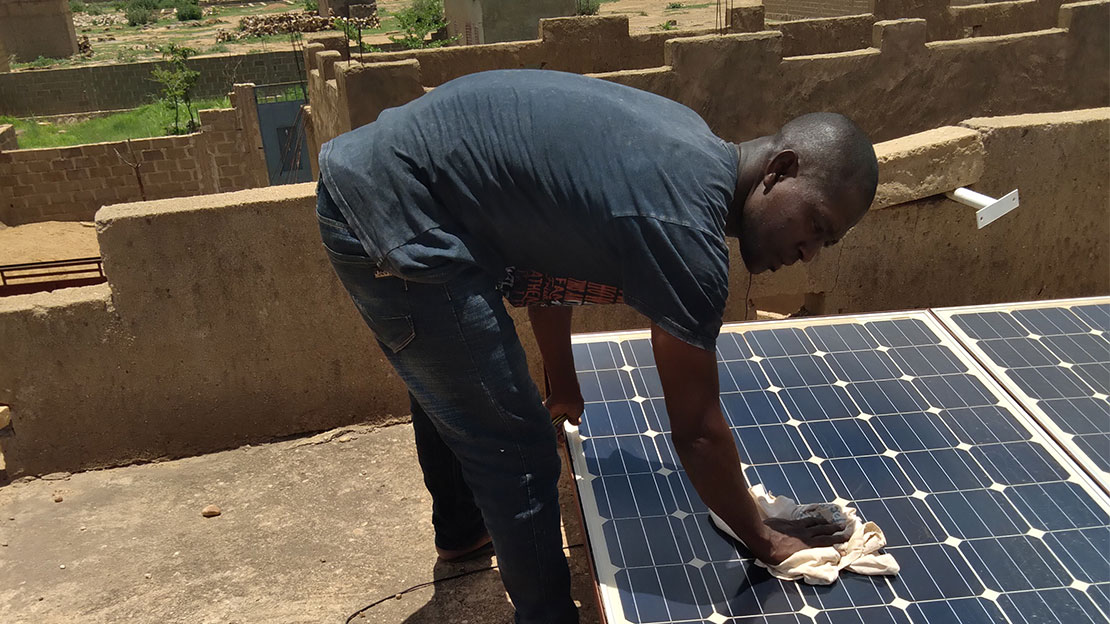Soutenu par Handicap International au Mali, le jeune Dicko répare un panneau solaire