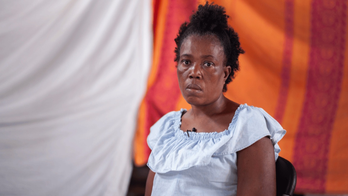 Portrait en gros plan d'une femme assise . Elle regarde le photographe avec une expression contemplative et légèrement attristée.
