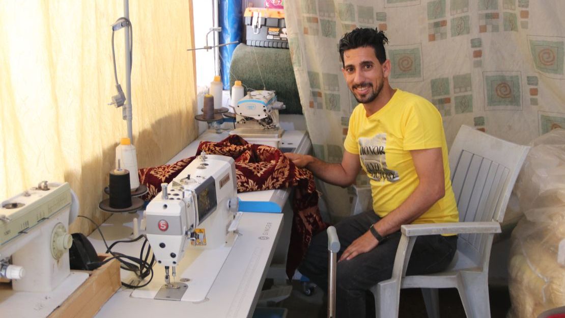 Ahmad, 29 ans, est assis dans son atelier de couture à son domicile en Jordanie