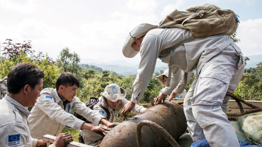 Une équipe de démineurs de Handicap International au Laos sécurisent une bombe avant de l'emmener sur un site pour la faire exploser.