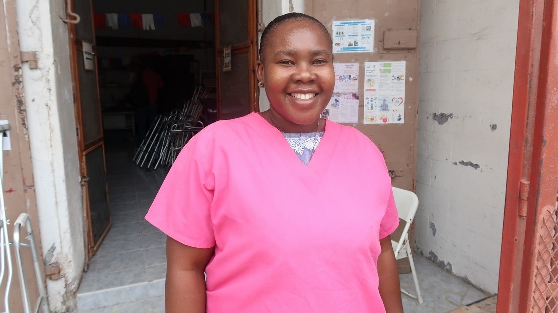 Guetchly-Nise, technicienne en réadaptation formée par Handicap International, sourit à l'extérieur d'un centre de réadaptation à Cayes, en Haïti. 2021