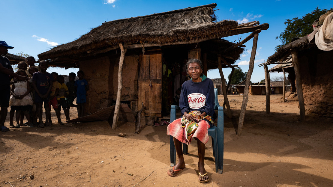 Nahy, 66 ans, est assise sur une chaise à l'extérieur de sa maison dans le Sud de Madagascar.