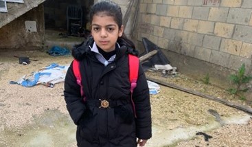 Une fillette pose devant sa maison dans un camp de réfugiés en Cisjordanie.