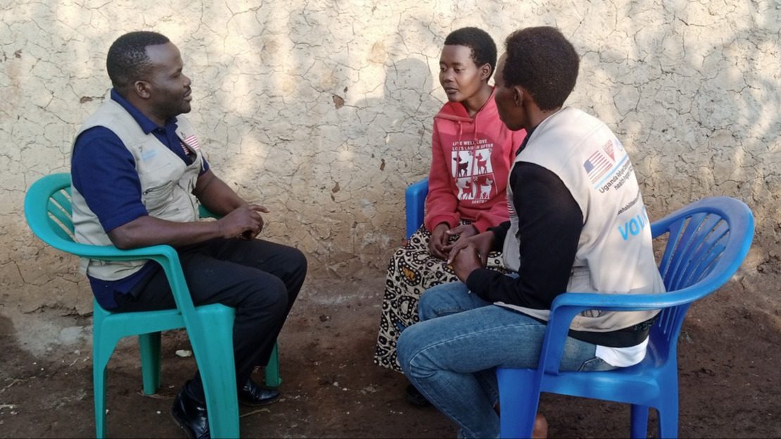 Trois personnes, deux femmes et un homme, sont assises en cercle sur des chaises en plastique.