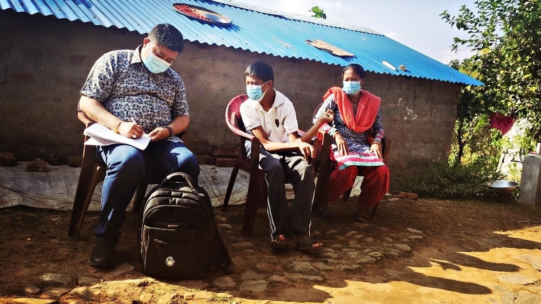 Siman avec sa mère et un membre de l'équipe de Handicap International au Népal