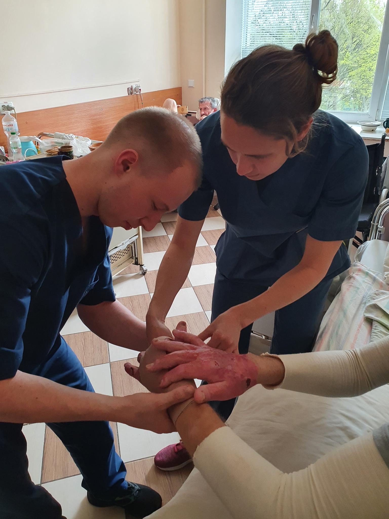 La kiné de HI Violette donne une formation pratique à Ivan, un étudiant ukrainien en kinésithérapie.