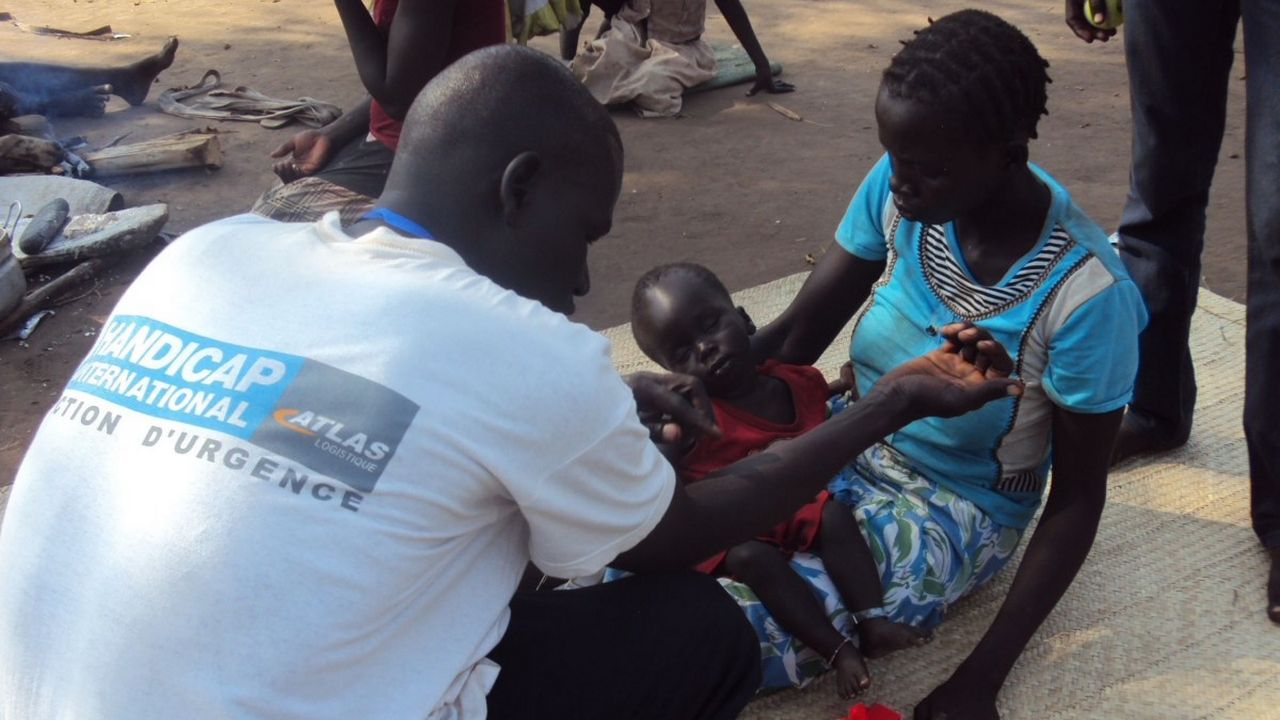 Une personne de Handicap International auprès d'un enfant