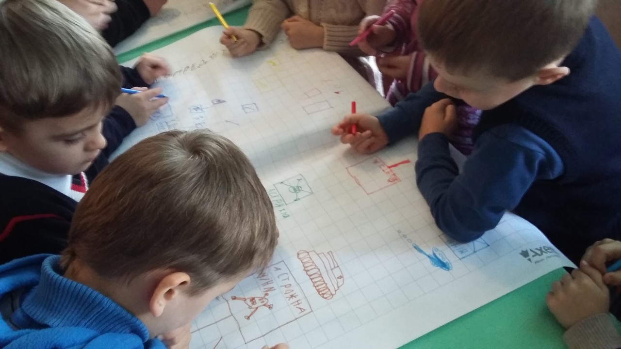 Des enfants dessinent des situations en présence de mines lors d'une session d'éducation aux risques en Ukraine menée par Handicap International.