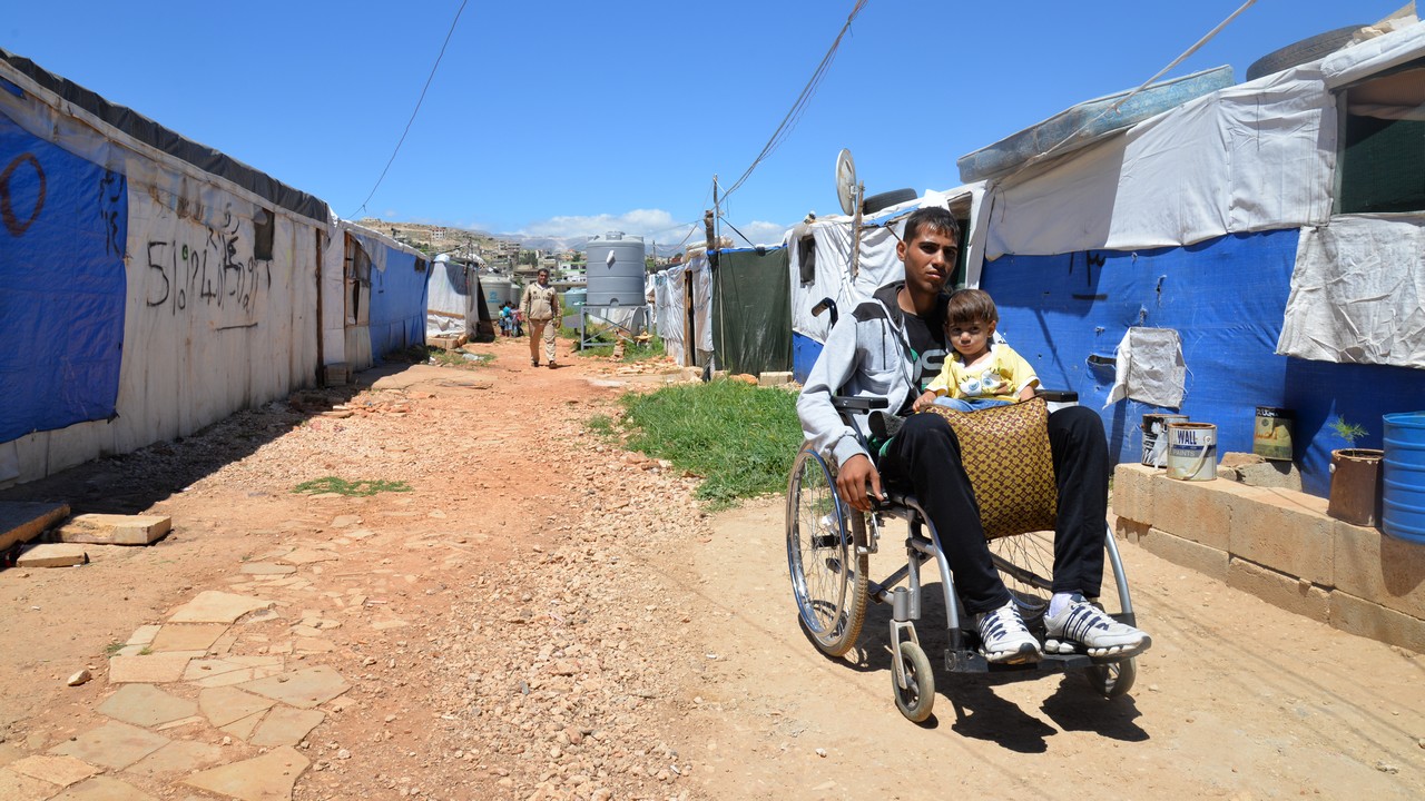 Ali et son petit frère Mohammad, à l’extérieur de leur tente dans le camp de fortune au Liban où Handicap International les accompagne.