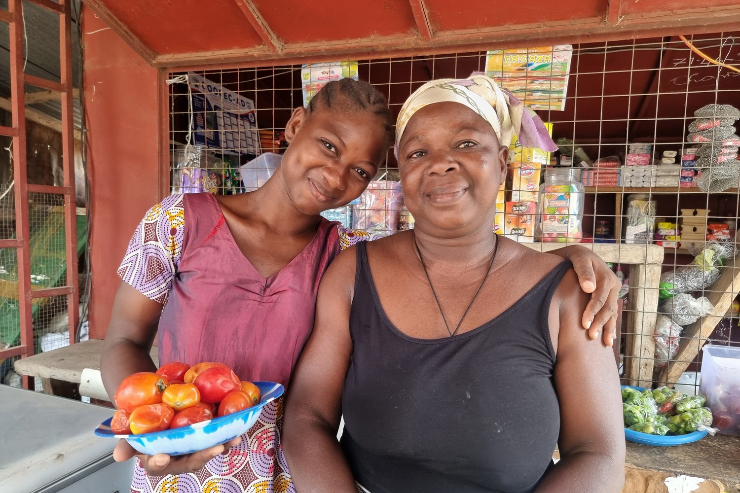 Au Togo, une mère et sa fille se tiennent debout et sourient au photographe.