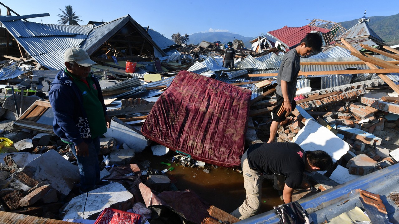 Des hommes recherchent toujours un membre de leur famille au village de Balaroa à Palu en Indonésie
