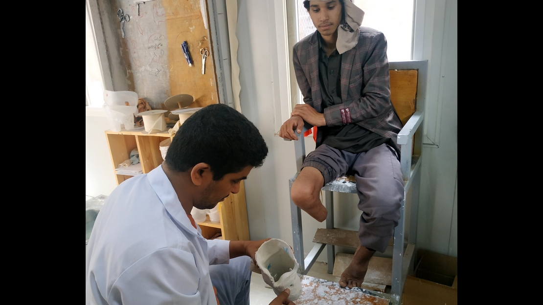 Abdel avec un kinésithérapeute de Handicap International au Yémen lors d'une session de suivi de sa prothèse