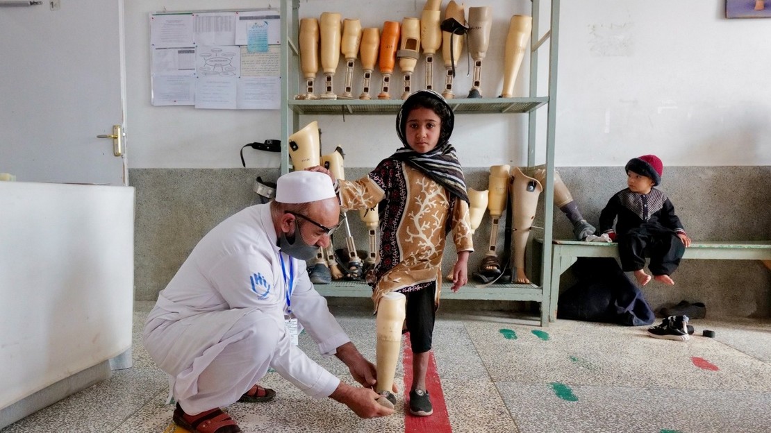 Amina, 7 ans, appareillée d'une prothèse, durant une séance de rééducation avec un kinésithérapeute de Handicap International au centre de réadaptation de Kandahar en Afghanistan. Amina a perdu sa jambe, sa mère et ses deux sœurs lors des violents affrontements qui ont eu lieu lors de la prise du pouvoir par les talibans en juillet 2021.