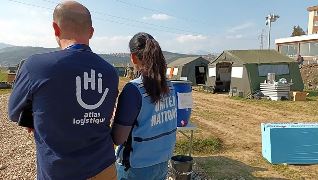 Deux personnes de dos sur le terrain, lors d'un déploiement humanitaire en Turquie suite au séisme de 2023.