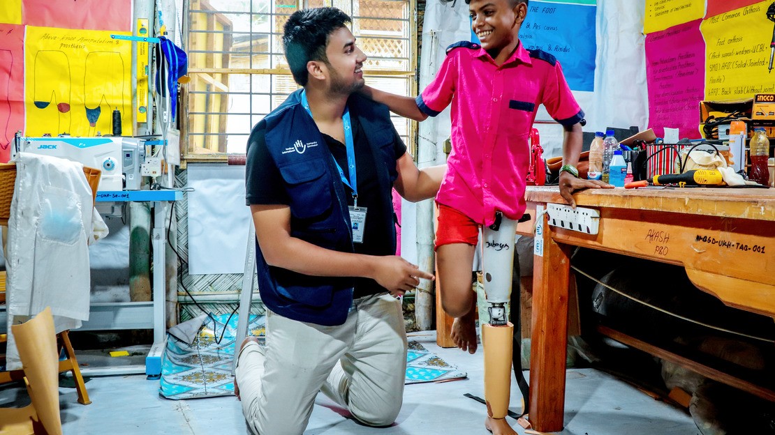 Au Bangladesh, un enfant essayant sa prothèse avec son orthoprothésiste.