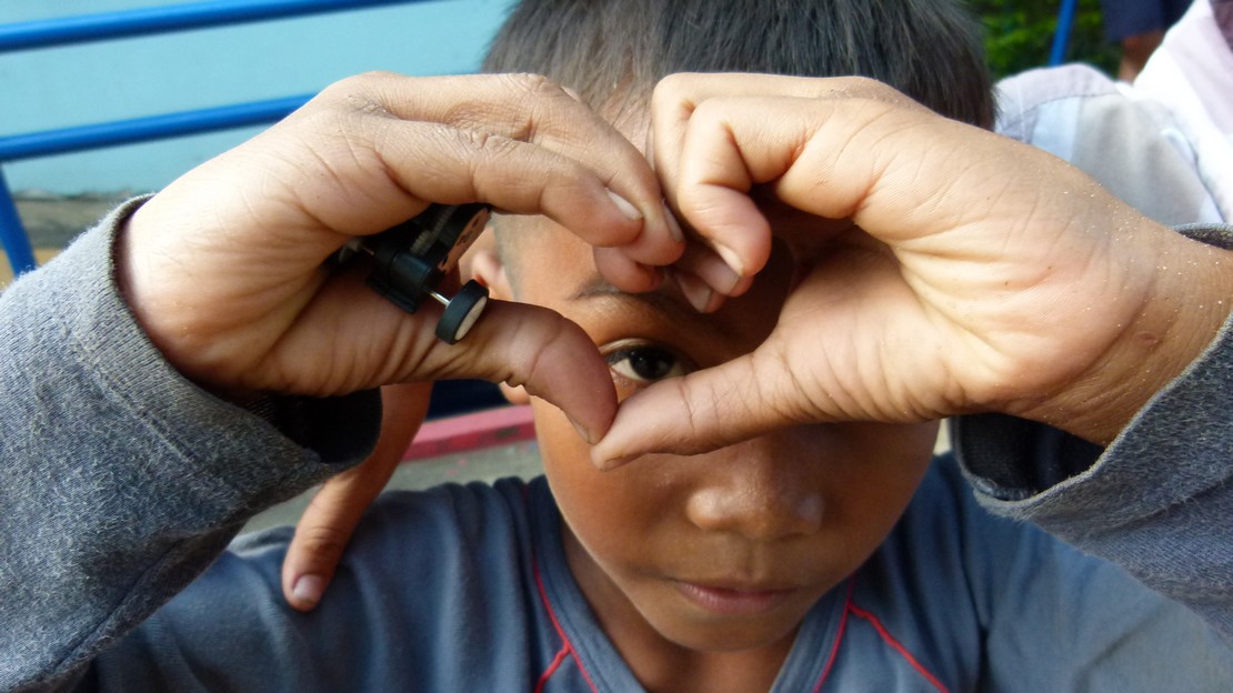 Un enfant fait un cœur avec ses mains.