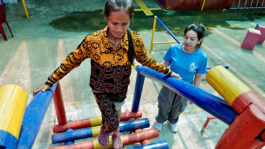 Raksmeymutta accompagne Kuy Navy, une patiente suivie au centre de Kampong Cham après avoir été amputée suite à l’explosion d’une mine.