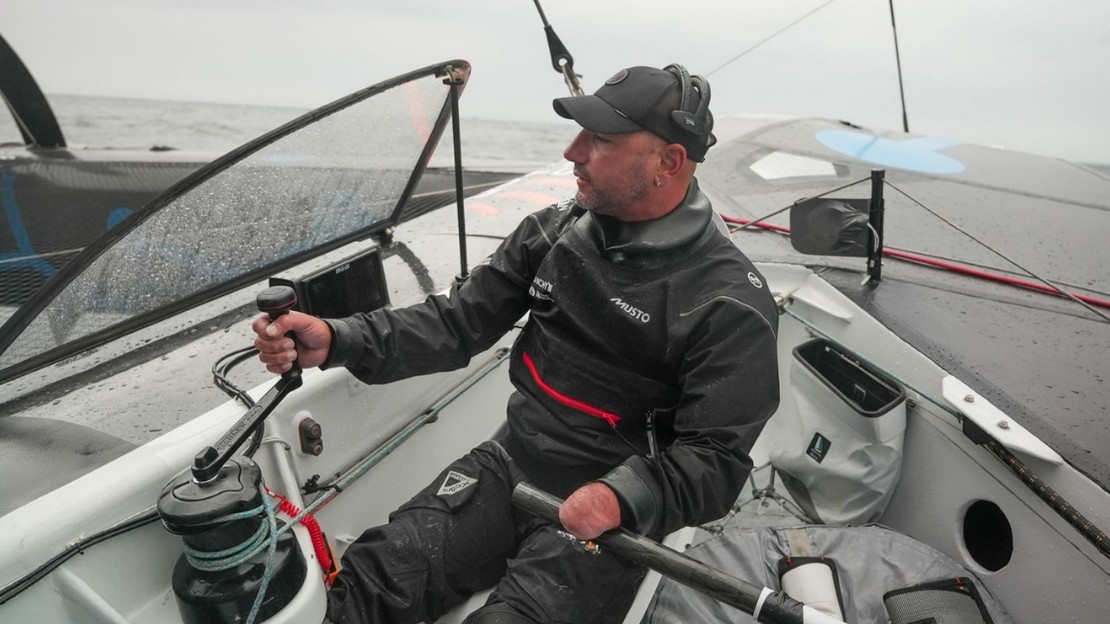 Un skipper en pleine manœuvre sur son bateau en mer.