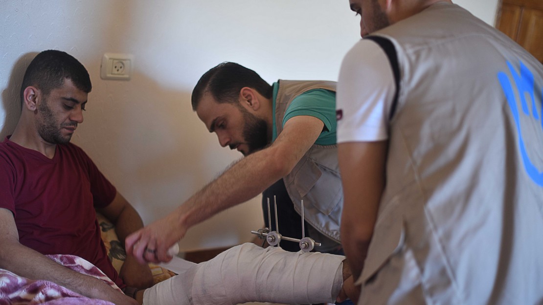 Un kinésithérapeuthe de HI auprès d'un patient 