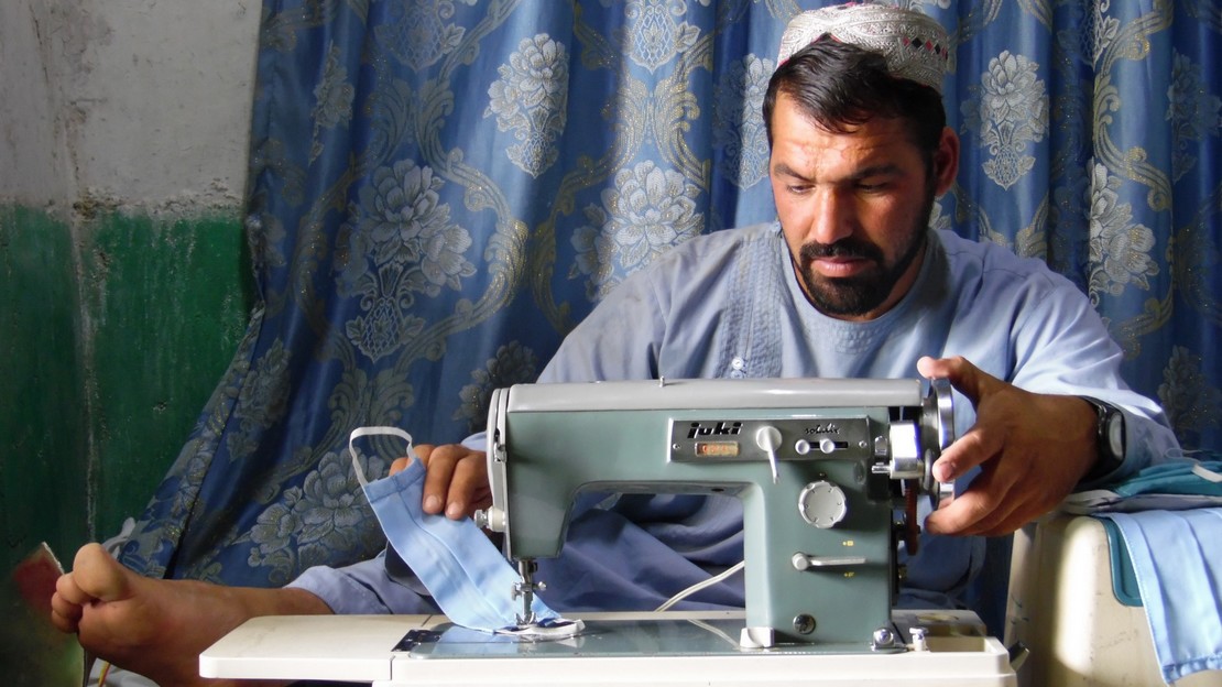 Blessé lors d'un conflit, Akhter participe à la lutte contre le Covid-19 en Afghanistan en cousant des masques à Kandahar, grâce au soutien de Handicap International.