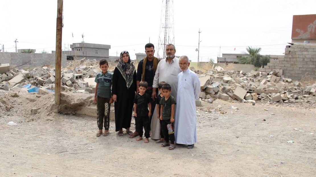 Une famille devant des immeubles détruits en Irak suite à des bombardements