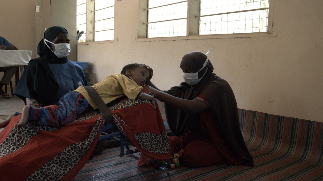 Hamze avec sa mère et sa kinésithérapeute au centre de Handicap International dans le camp de réfugiés de Dadaab au Kenya