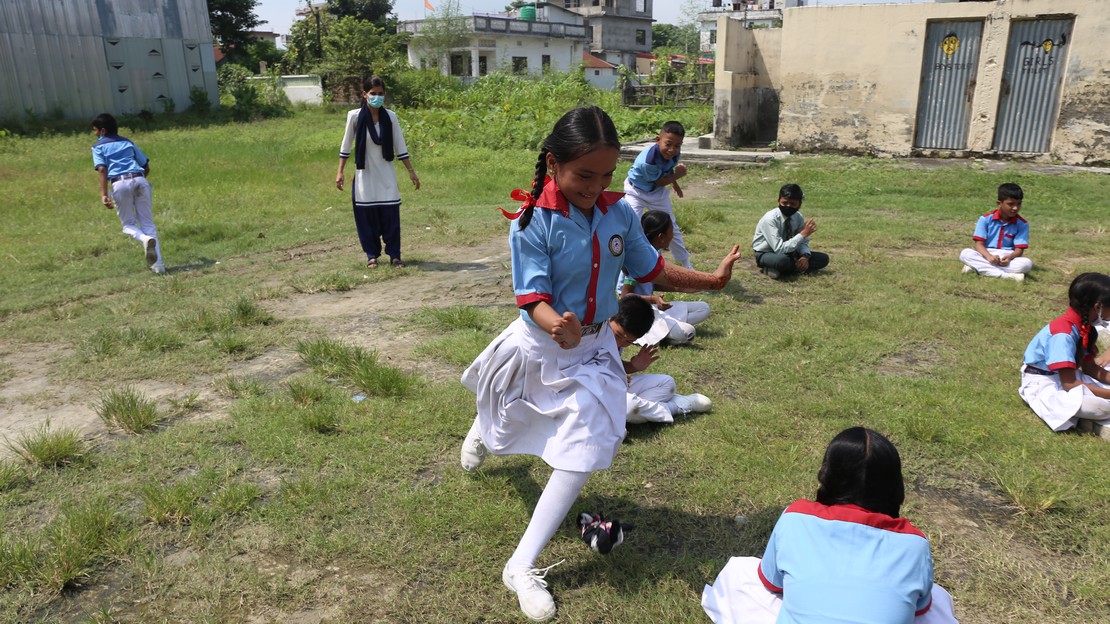 Unisha dans la cour de l'école en train de jouer avec ses camarades, dont beaucoup ignoraient qu'elle portait une prothèse