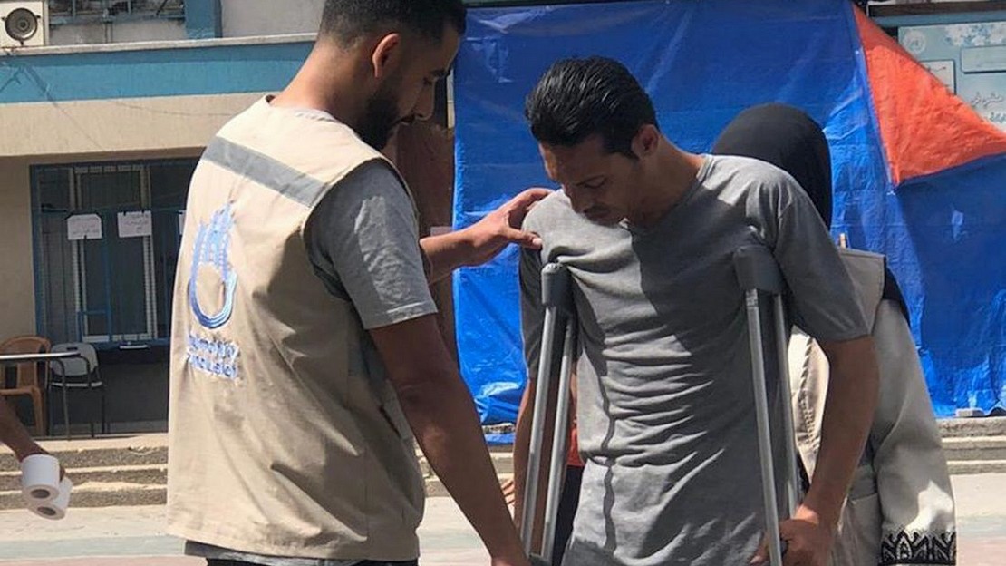 Haitham dans un camp de déplacés, aidant un bénéficiaire