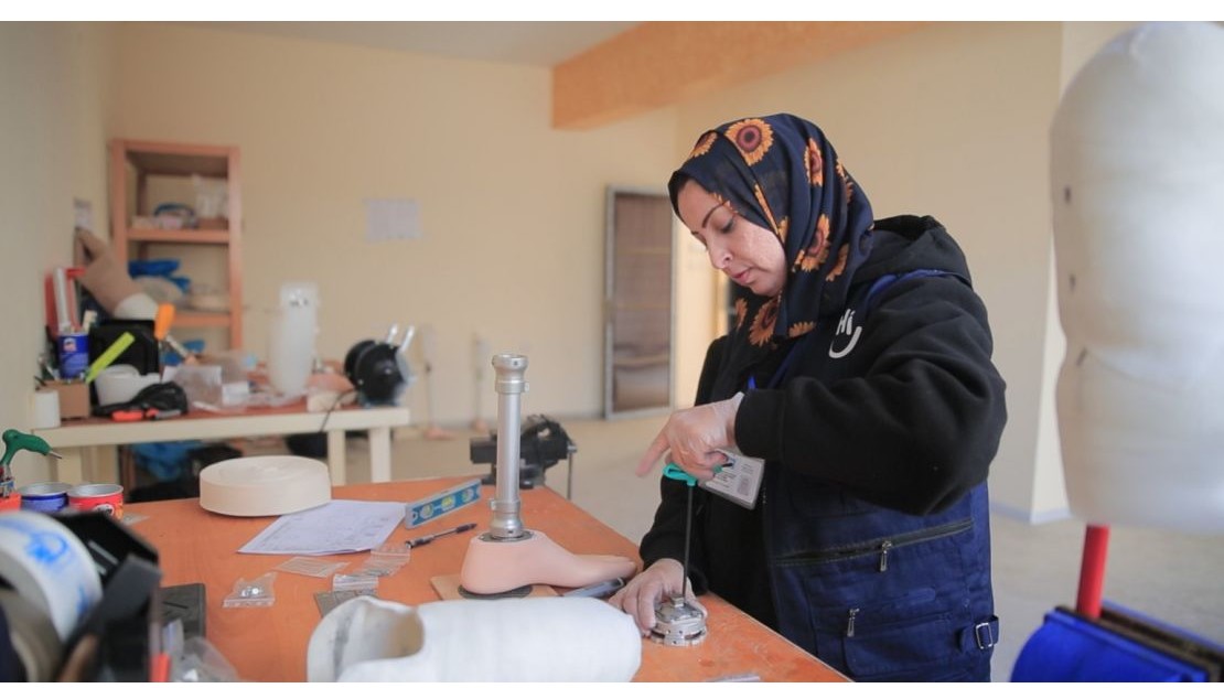 Dans un centre d'appareillage, une femme est en train de fabriquer une prothèse de jambe.