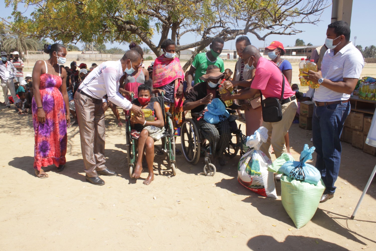 À Madagascar, en extérieur, distribution de produits alimentaires aux populations, notamment à des personnes en fauteuil roulant.