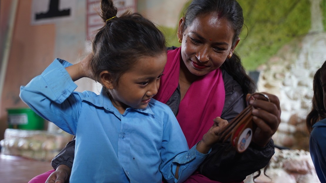 Aakanksha, 6 ans, et sa professeur, Nita, utilisant le porte-clés de communication fourni par HI pour l’aider à mieux se faire comprendre en classe.