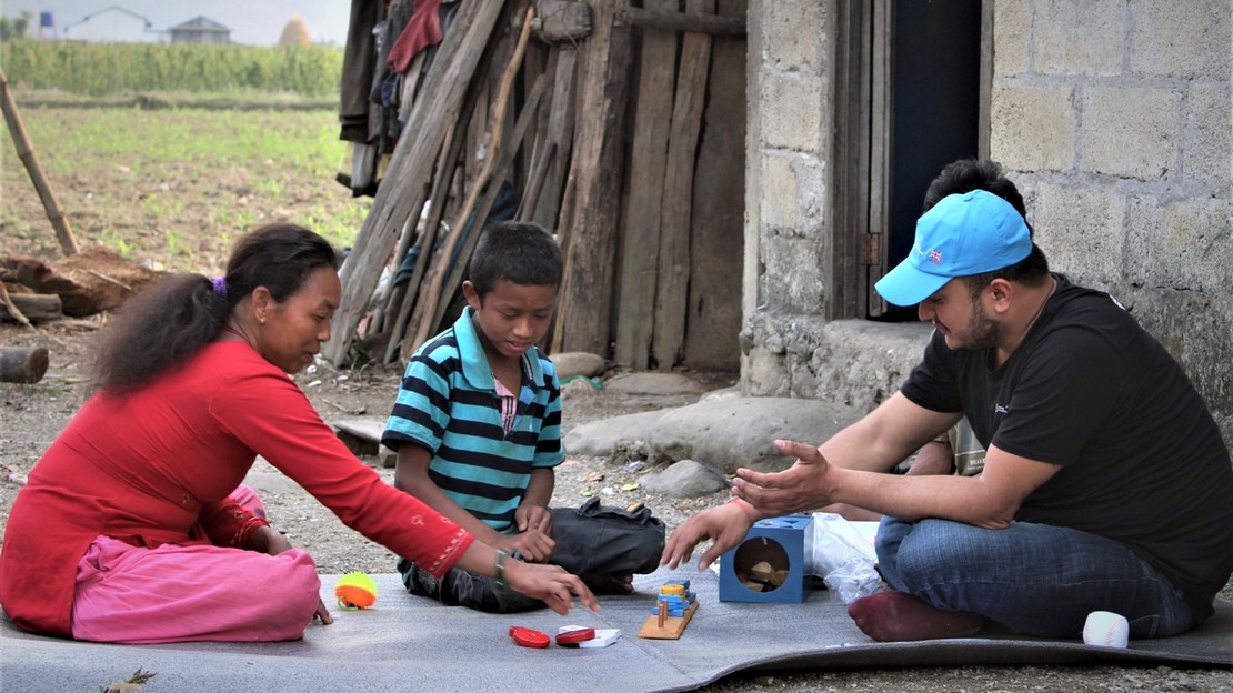 Lors d'une visite à domicile de Bimal, son enseignant itinérant, Milan réalise à domicile des activités d'apprentissage en utilisant divers supports pour développer des compétences de base en lecture, écriture et calcul. Sa mère observe activement la séance pour soutenir son apprentissage à la maison.