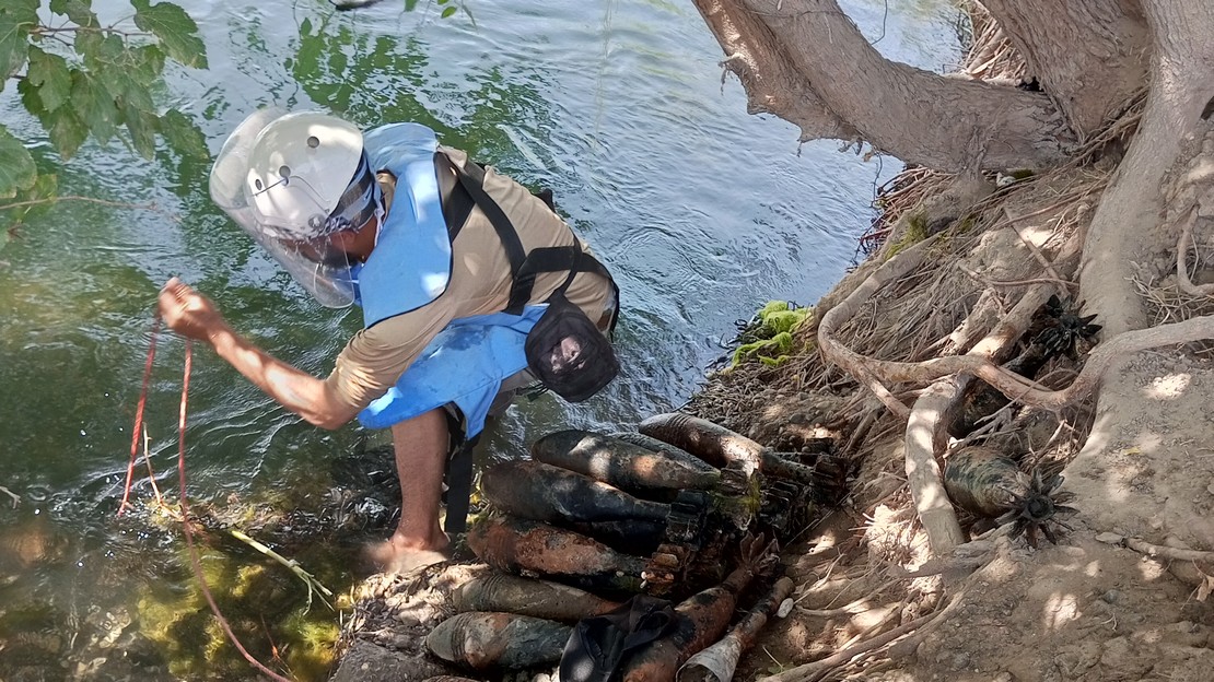 Un démineur de Handicap International retire des engins explosifs au bord d'une rivière à Raqqa dans le Nord de la Syrie.