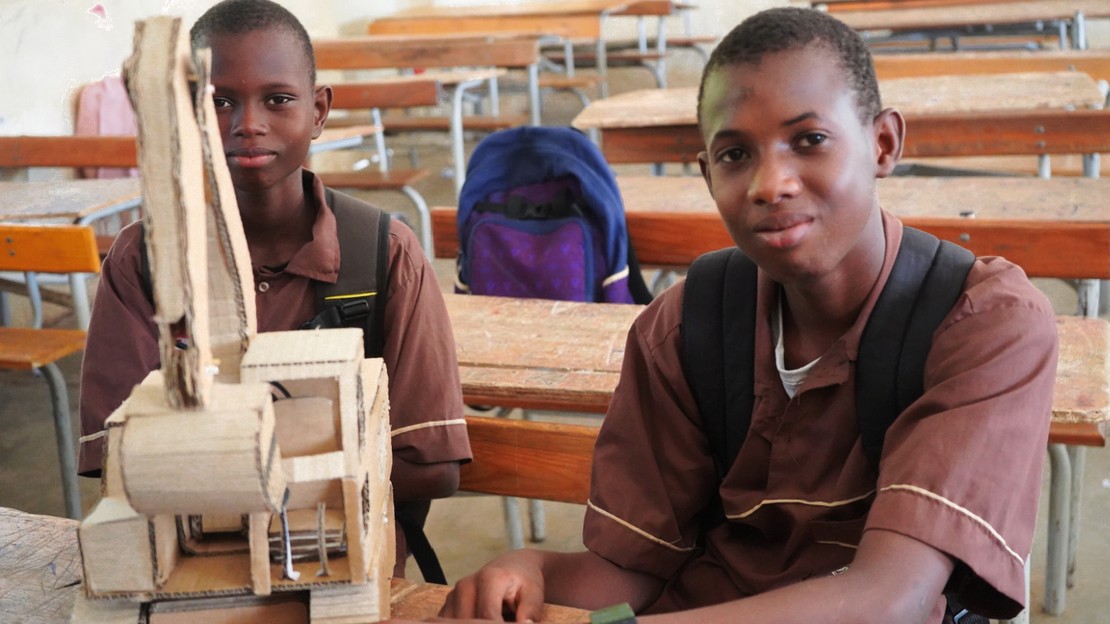 Mohamed Sall (à droite) et son ami Mamadou Samba, également non entendant, posent à côté de l'engin de chantier confectionné par Mohamed.