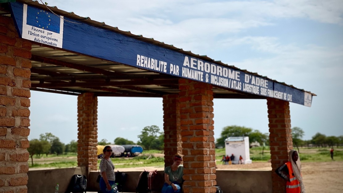 Plusieurs personnes se tiennent sous un auvent à l'entrée d'un aérodrome réhabilité au Tchad.