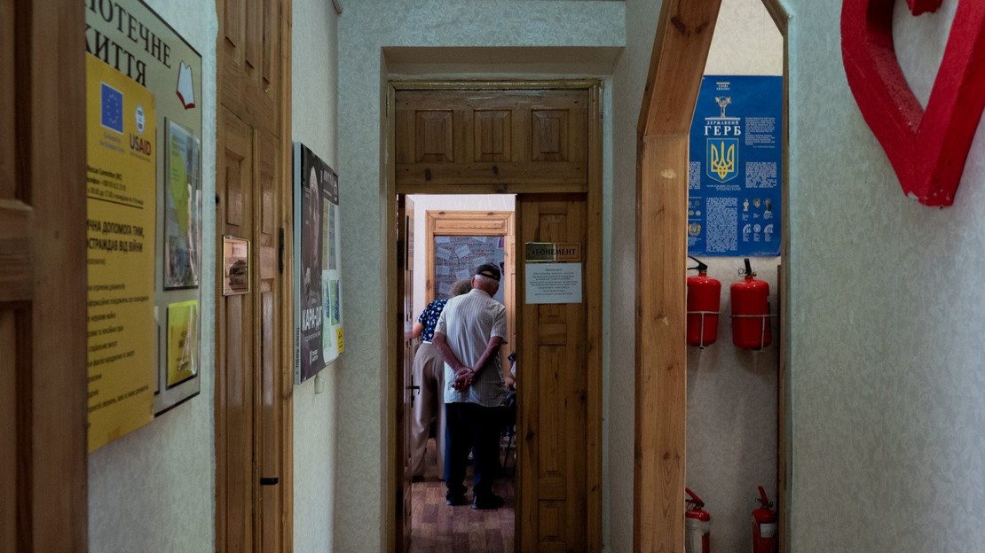 Des Ukrainiens déplacés attendent d’être reçus par les équipes de protection de Handicap International dans la bibliothèque pour enfants de Yurivka, dans l’est de l’Ukraine.