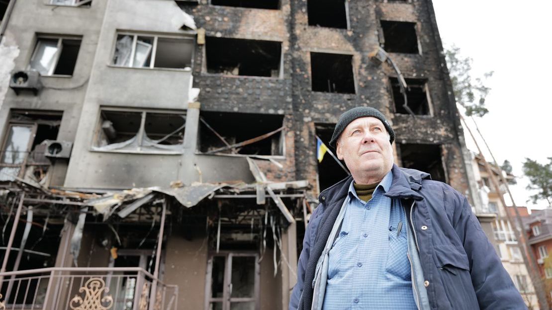 Un homme se tient à côté de maisons détruites par la violence armée à Irpin, en Ukraine.