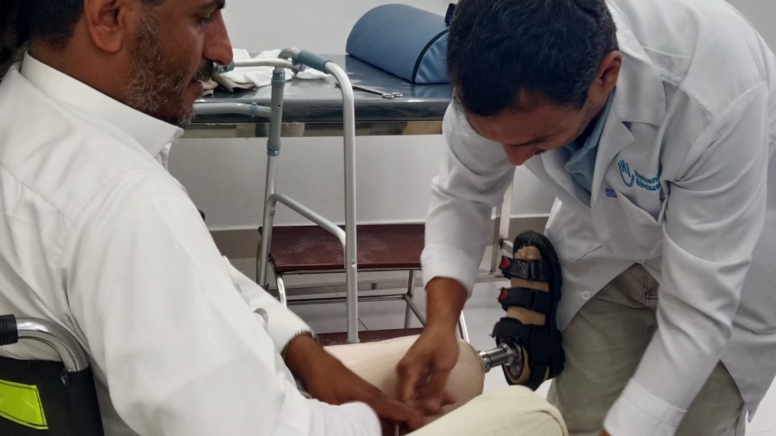 Un homme en train de mettre ses deux prothèses de jambe.