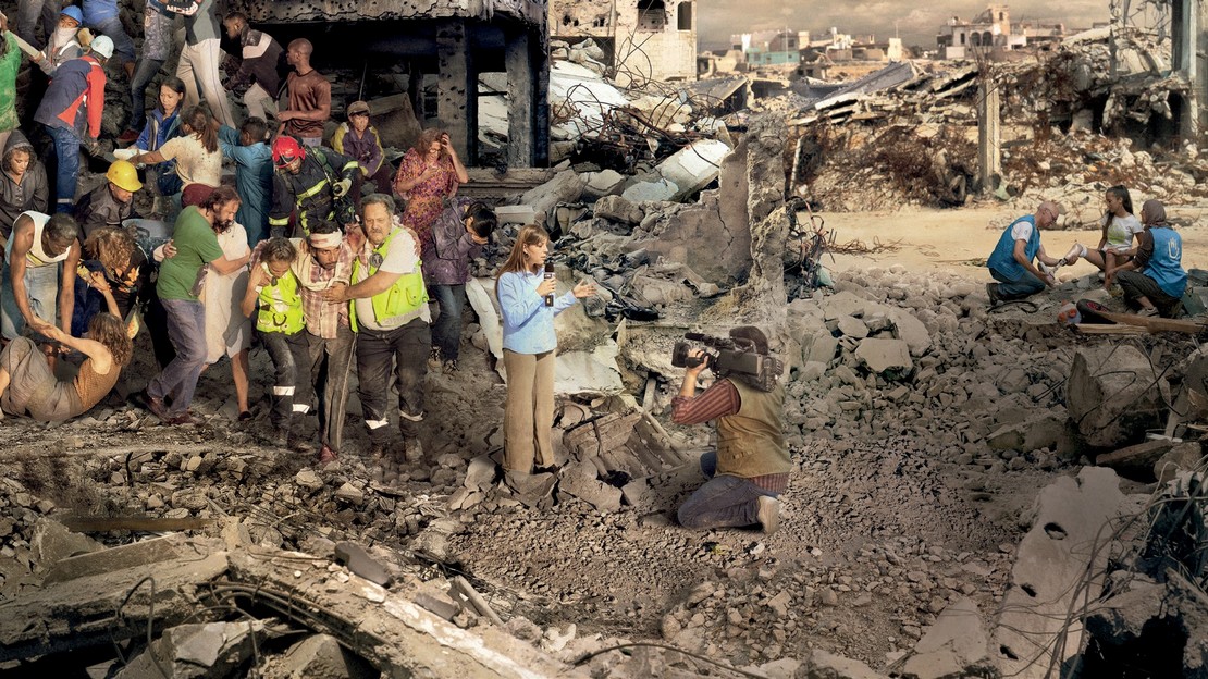 Scène de catastrophe humanitaire qui met en perspective un groupe de personnes ayant besoin d'aide, derrière un duo de journalistes en train de faire un direct à la télé, et au second plan une équipe de Handicap International intervenant auprès d'une jeune femme amputée.